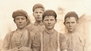 Kinderarbeit in den USA: Gruppe von Knaben, die in einer Spinnerei in Macon, Georgia, arbeiten. - Foto (Lewis W. Hine), Januar 1909. © picture alliance Foto: Lewis W. Hine, akg-images