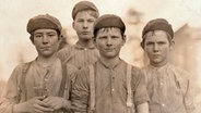 Kinderarbeit in den USA: Gruppe von Knaben, die in einer Spinnerei in Macon, Georgia, arbeiten. - Foto (Lewis W. Hine), Januar 1909. © picture alliance Foto: Lewis W. Hine, akg-images