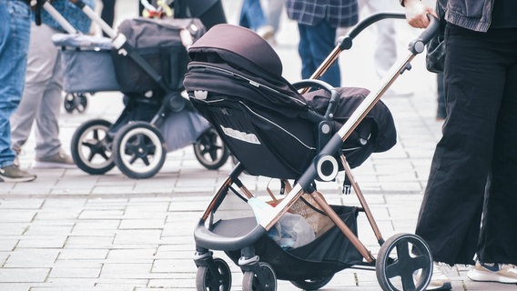 Zwei Kinderwagen werden durch die Innentadt gezogen. © imago images / Michael Gstettenbauer 