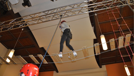 Eine Frau benutzt einen Kletterparcours.  Foto: Peter Bartelt