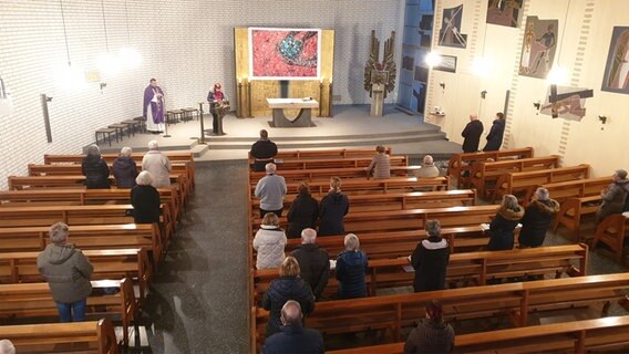 Menschen nehmen an einem Gottesdienst in einer Kirche teil. © NDR Foto: Johannes Tran