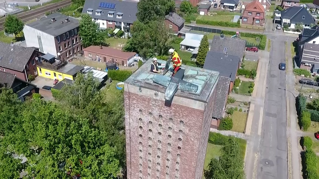 Itzehoe: Einsatzkräfte der Feuerwehr sichern ein abgerissenes Kirchenkreuz.