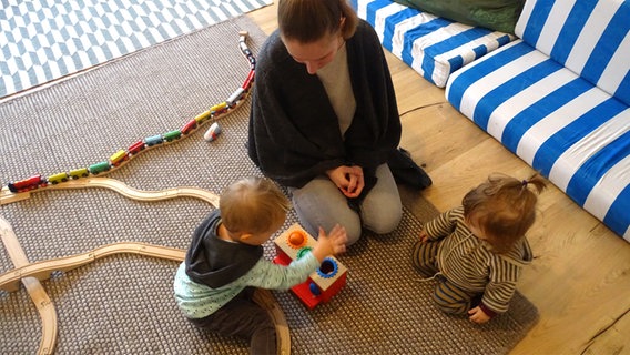 Frau und zwei kleine Kinder beim Spielen © NDR Foto: Anina Laura Pommerenke