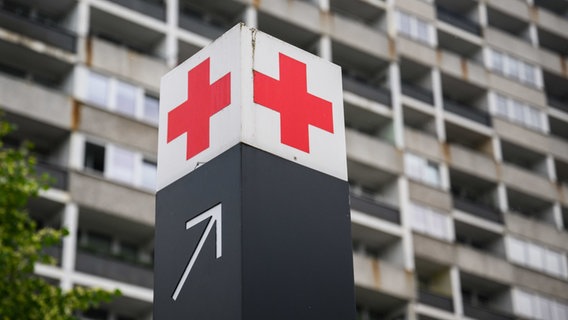 Ein Schild mit einem roten Kreuz weist den Weg zur Notaufnahme. © dpa Foto: Julian Stratenschulte