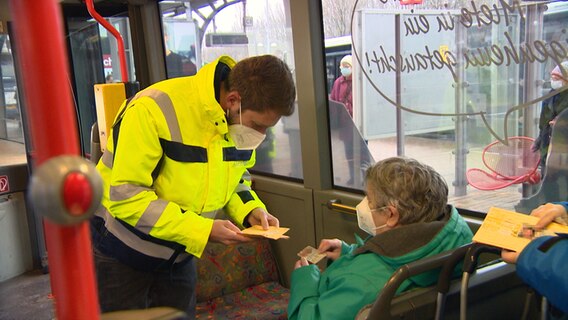 Ein Mitarbeiter von Aktivbus kontrolliert 3G-Nachweise bei den Fahrgästen eines Linienbuses in Flensburg. © NDR 