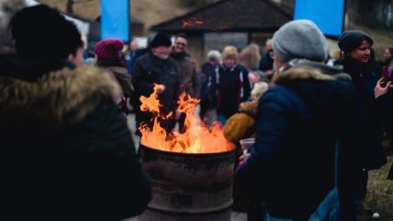 Besucher des Konzerts gegen Kälte wärmen sich an Feuertonne. © NDR Foto: Yosua Pandelaki