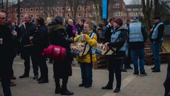 Mitarbeiter der Kieler Stadtmission verkaufen aus Bauchläden Nüsse an die Konzertbesucher. © NDR Foto: Yosua Pandelaki