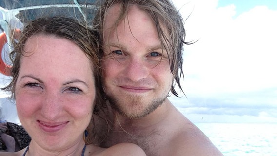 Eine Frau und ein Mann lächeln an einem Strand in eine Kamera. Eine Frau und ein Mann lächeln an einem Strand in eine Kamera. © Hannes Schmidt / Anne Struwe-Schmidt