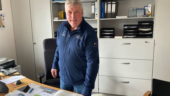 Ein Mann steht in einem Büro und deutet auf eine auf einem auf einem Tisch liegende Karte Ein Mann steht in einem Büro und deutet auf eine auf einem auf einem Tisch liegende Karte © NDR Foto: Andreas Rackow