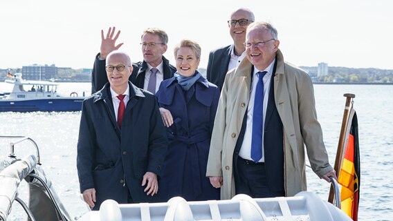 Daniel Günther (CDU, l-r), Schleswig-Holsteins Ministerpräsident, Manuela Schwesig (SPD), Mecklenburg-Vorpommerns Ministerpräsidentin, Peter Tschentscher (SPD), Hamburgs Erster Bürgermeister, Andreas Bovenschulte (SPD), Bremens Bürgermeister und Stefan Weil (SPD), Niedersachsens Ministerpräsident stehen auf einem Schiff des Marinekommandos. © dpa-Bildfunk Foto: Axel Heimken