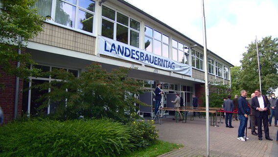 Ein weißer Banner hängt an der Fassade eines Gebäudes beim Landesbauerntag 2021 in Rendsburg. © NDR 