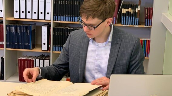Helge-Fabien Hertz sitzt am Tisch und arbeitet. © NDr Foto: Corinna Below