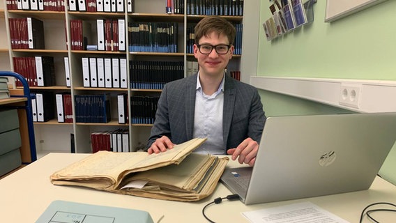 Helge-Fabien Hertz sitzt am Schreibtisch und recherchiert für seine Dissertation. © NDr Foto: Corinna Below
