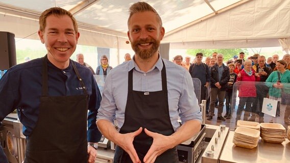 Menschen stehen an einem Stand des NDR: Kochshow mit Philipp Jeß (rechts) und Volker Fuhrwerk.  Foto: Karin Hausschildt