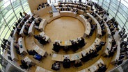 Blick von oben in Fisheye-Optik: Die Abgeordneten haben im Landeshaus in Kiel die Plätze eingenommen. Der Landtag kommt hier zu seiner konstituierenden Sitzung nach der Landtagswahl zusammen. © dpa-Bildfunk Foto: Carsten Rehder