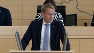 Ministerpräsident Daniel Günther (CDU) steht am Rednerpult im Landtag. © NDR Foto: Screenshots