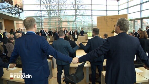 Die Abgeordneten des Landtag halten sich an den Händen für den Gedenktag der Ukraine. © NDR 