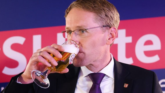 Daniel Günther (CDU), Ministerpräsident von Schleswig-Holstein und Spitzenkandidat seiner Partei, trinkt bei der Wahlparty ein alkoholfreies Bier. © dpa-Bildfunk Foto: Christian Charisius/dpa