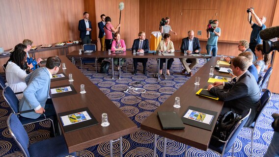 Die Verhandlungsteams von CDU (M), FDP (R) und Grünen (L) sitzen in einem Konferenzraum im Maritim Hotel Bellevue Kiel. © picture alliance/dpa Foto: Jonas Walzberg