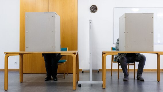 Zwei Wähler füllen in der Wahlkabine ihre Stimmzettel aus © dpa-Bildfunk Foto: Markus Scholz