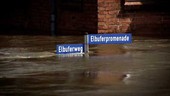 Straßenschilder "Elbuferweg" und "Elbuferpromenade" stehen fast komplett unter Wasser in Lauenburg bei der Flutkatastrophe 2013. © NDR 