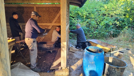 Handwerker bei der Fertigstellung einer Lehmhaus Fassade. © Frank Goldenstein Foto: Frank Goldenstein