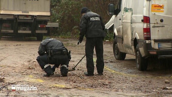 Polizisten untersuchen einen Tatort.  