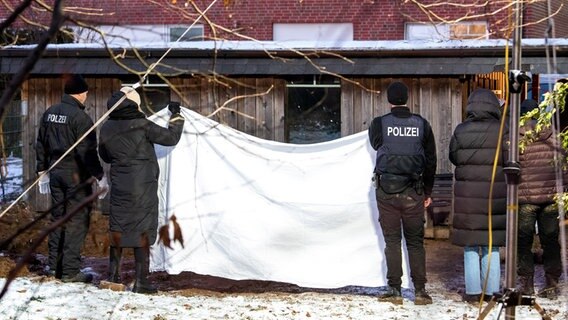 Polizeikräfte verdecken einen Tatort. © dpa_Daniel Bockwoldt 