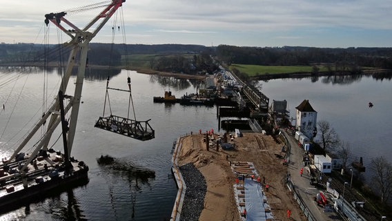 Der größte Schwimmkran Deutschlands hebt ein Klappteil der Lindaunisbrücke und bringt es ans Ufer. © NDR 
