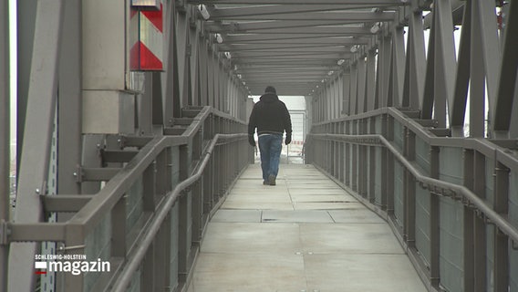 Ein Mann geht über die Lindaunisbrücke an der Schlei. © NDR 