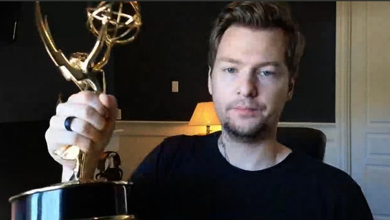 Produzent und Autor Christian Linke, hält einen Emmy in der Hand. © NDR 