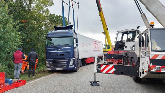 Ein Lkw wurde neben der Autobahn mithilfe eines Krans aufgerichtet. © NDR Foto: Hannah Böhme