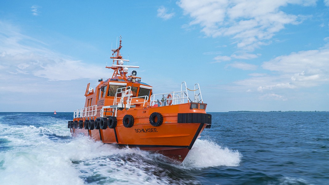 Das orangene Boot der Kieler Lotsen fährt über das Wasser.
