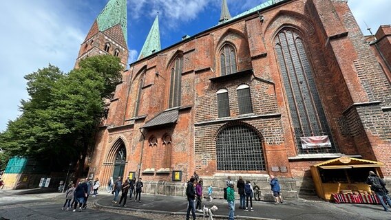 Passanten stehen an der Lübecker St. Marienkirche. © NDR Foto: Hauke Bülow