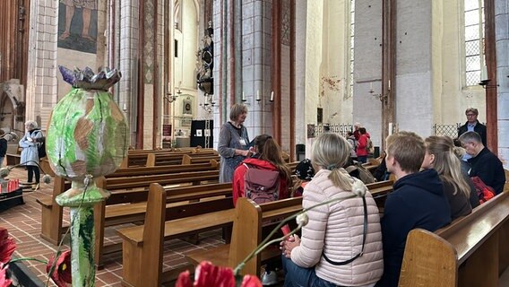 Eine Besuchergruppe lauscht einer Führung in der Lübecker St. Marienkirche. © NDR Foto: Hauke Bülow
