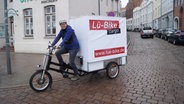 Ein Mann fährt mit seinem Lastenrad durch Lübeck. © NDR Foto: Astrid Wulf