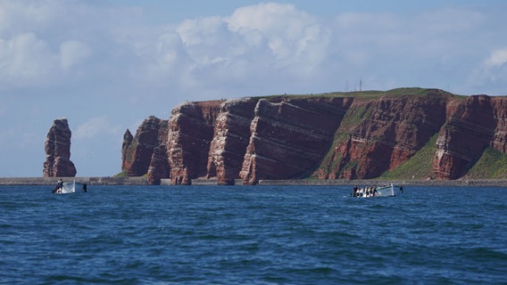 Die Helgoländer Küste. Auf dem Wasser davor fahren zwei Boote. © dpa-Bildfunk Foto: Marcus Brandt