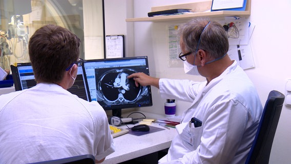 Ärzte begutachten eine Aufnahme eines Computertomographen. © NDR Foto: Sven Jachmann