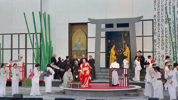 Schauspieler stehen auf der Bühne bei einer Aufführung von "Madame Butterfly". © NDR Foto: Mechthild Maesker