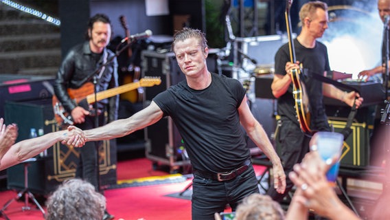 Frontmann Björn Dixgård reicht einem Fan die Hand. © NDR Foto: Gino Laib