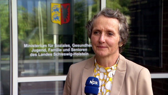 Frau Dr. Anne Marcic steht vor dem Eingang des Ministerium für Soziales, Gesundheit, Jugend, Familie und Senioren des Landes Schleswig-Holstein © NDR 