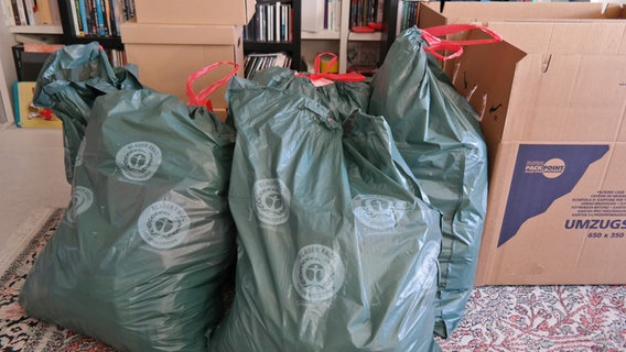 Plastiksäcke mit aussortierter Kleidung stehen in einem Schlafzimmer. © NDR Foto: Jennifer Lange