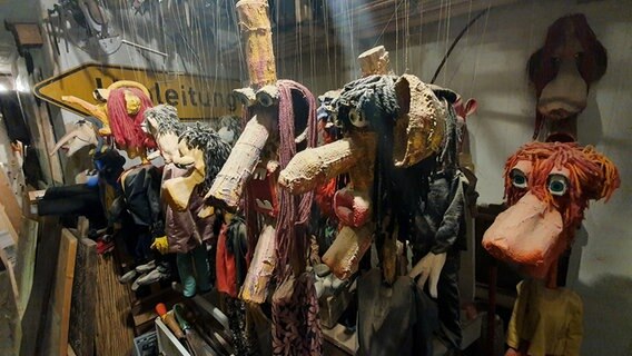 Eine Reihe von Marionetten hängt in der Werkstatt von Peter Beyer. © NDR Foto: Sebastian Parzanny