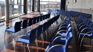 Blaue Stühle sind zu Sitzreihen in einem ansonsten leeren Konferenzraum aufgereiht © Silja Kruse/NDR Foto: Silja Kruse/NDR