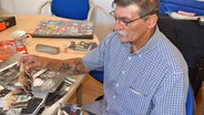 Matthäus Weiß beim Betrachten von Fotos im Büro des Landesverbandes der Sinti und Roma in Kiel-Elmschenhagen © NDR Foto: Ernst Christ