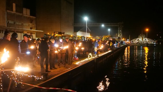 Mehrere Menschen stehen mit Lichtern am Ufer der Nord-Ostsee-Kanals © Daniel Friederichs Foto: Daniel Friederichs