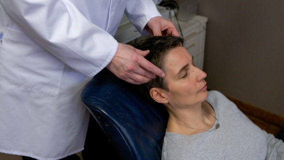 Eine Frau wird von einem Arzt auf Migräne untersucht. © NDR 