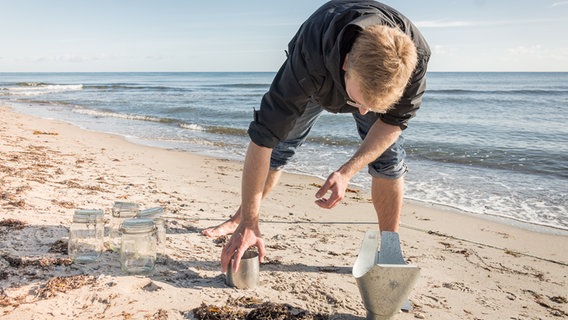 Ein Mann entnimmt Sandproben an einem Strand. © Future Ocean Foto: Svenja Hardel