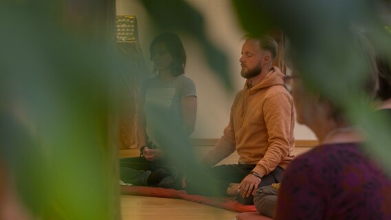 Ein Mann meditiert in einem Raum. © NDR Foto: NDR