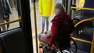 Eine Frau im Rollstuhl steigt aus einem Bus aus, indem der der Bus sich absenkt. © Stadtwerke Lübeck 